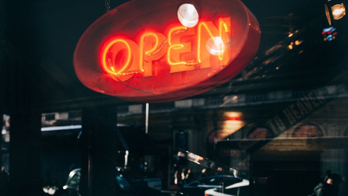 Neon OPEN sign glowing in a shop window at night