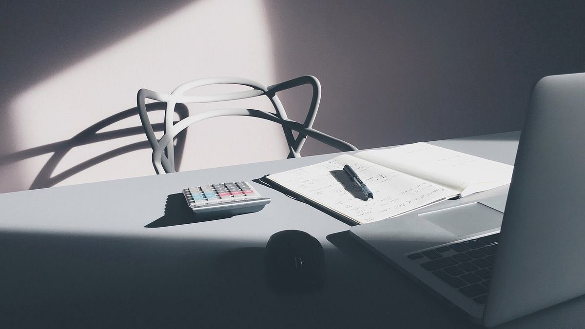 Laptop, calculator and notebook on a desk, representing website budget planning